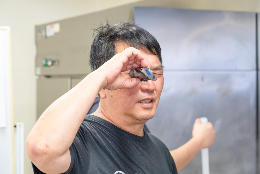 2025年7月開催分|生徒さんがラーメンスープの濃度を手に持って測っている