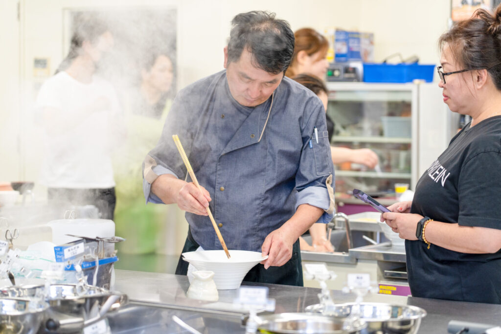 2025年7月開催分|最終日の模擬店舗の様子、生徒さんがラーメンを作っている