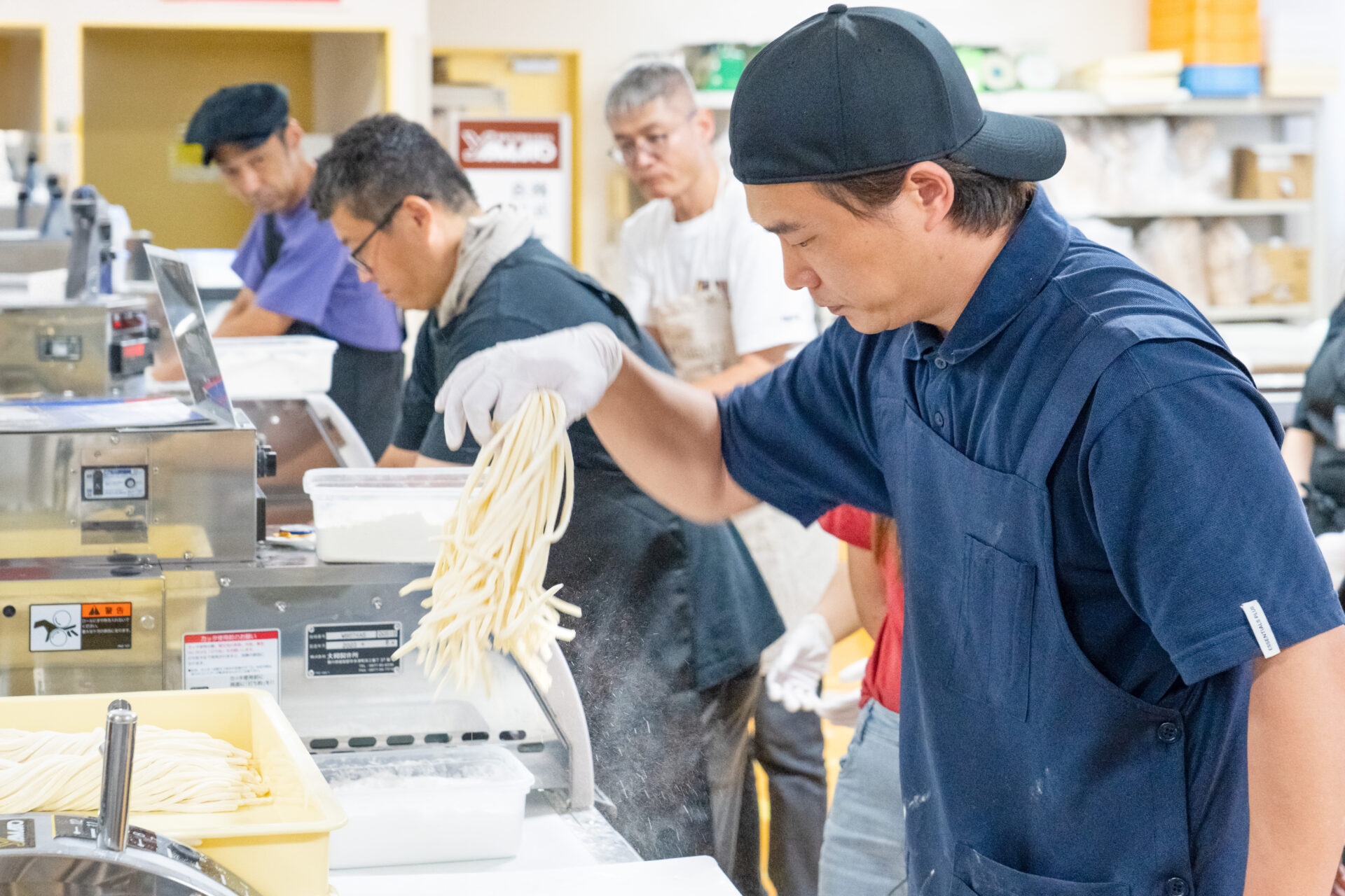大和うどん学校の生徒さんが製麺機を使って製麺をしている