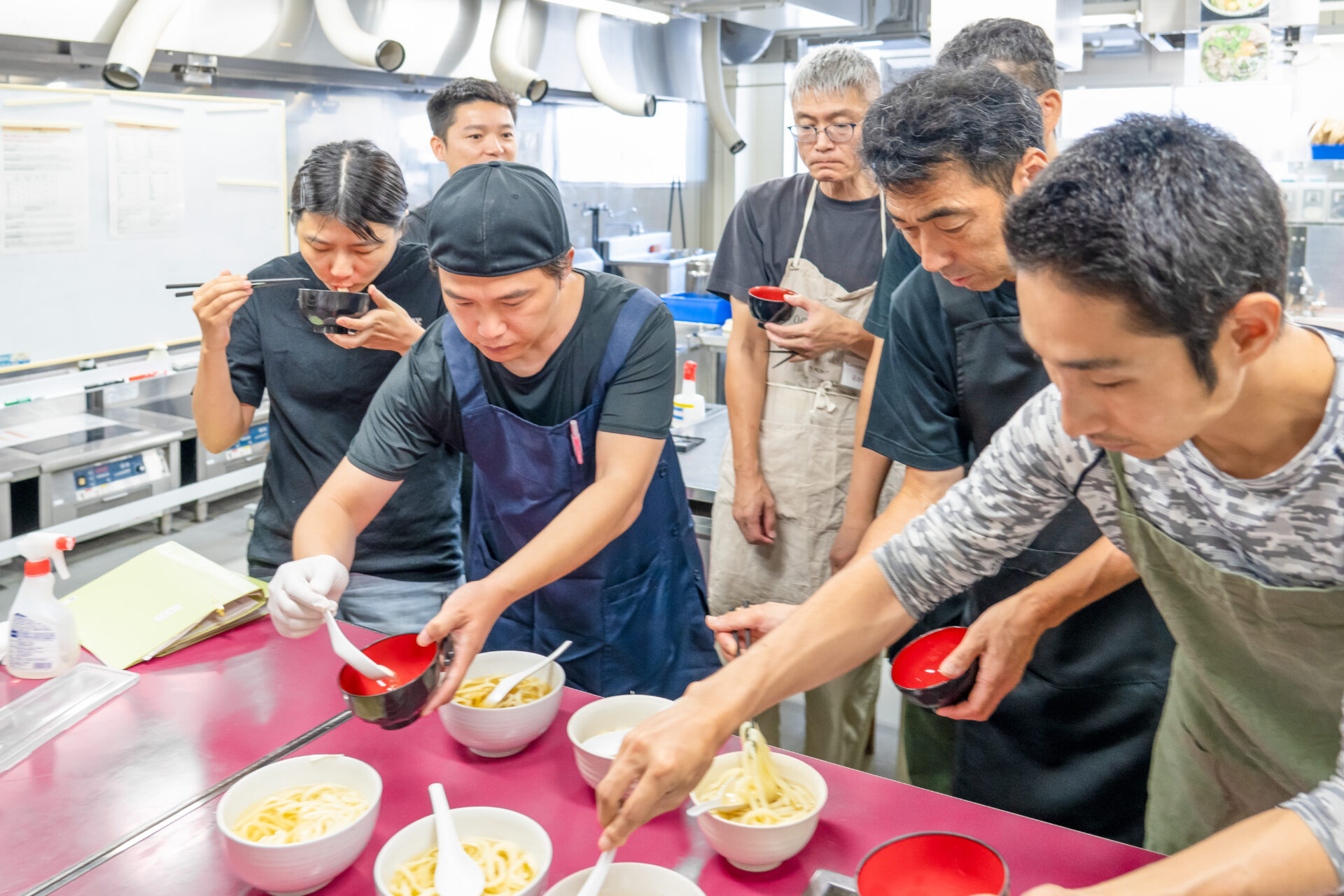 大和うどん学校の生徒さんが試食をしている