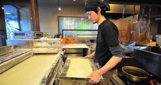 cost_11.jpg 製麺機で製麺を行っている男性